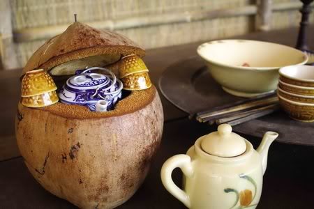 bình trà được đặt vào trọn trong cái vỏ dừa khô